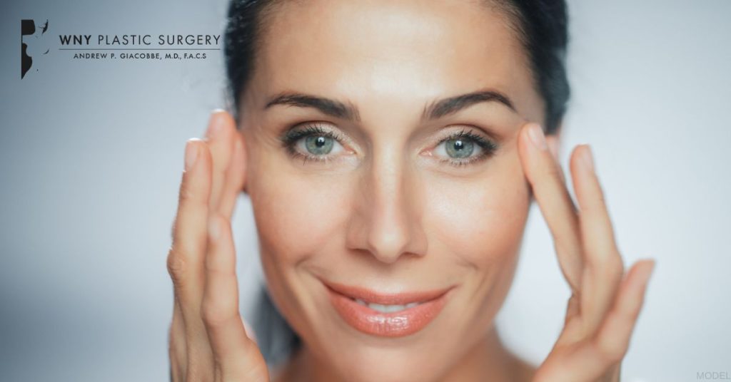 Smiling woman touching the sides of her eyes (model)